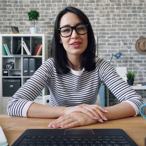 a woman sitting at a desk in front of a laptop